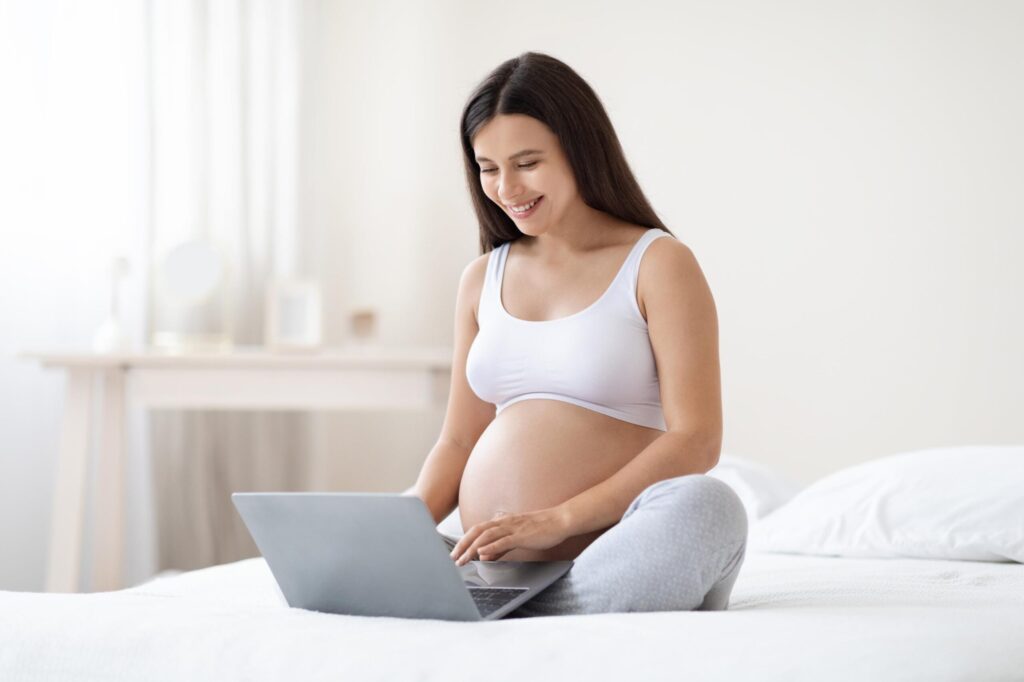 happy-pregnant-woman-using-computer-at-home-2023-11-27-05-01-04-utc (1)